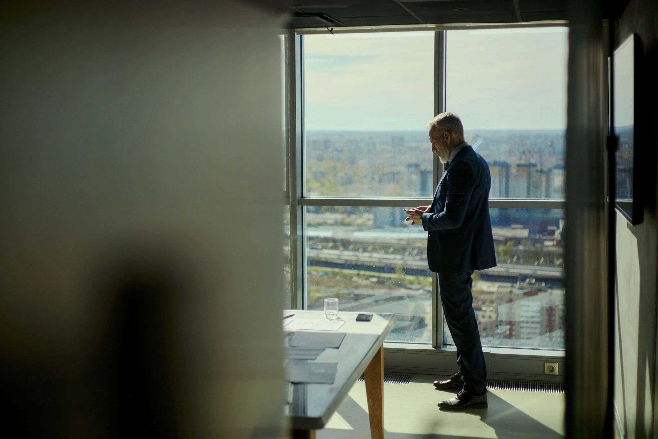 Middle Aged Businessman Reviewing Phone during Oil Industry Meeting
